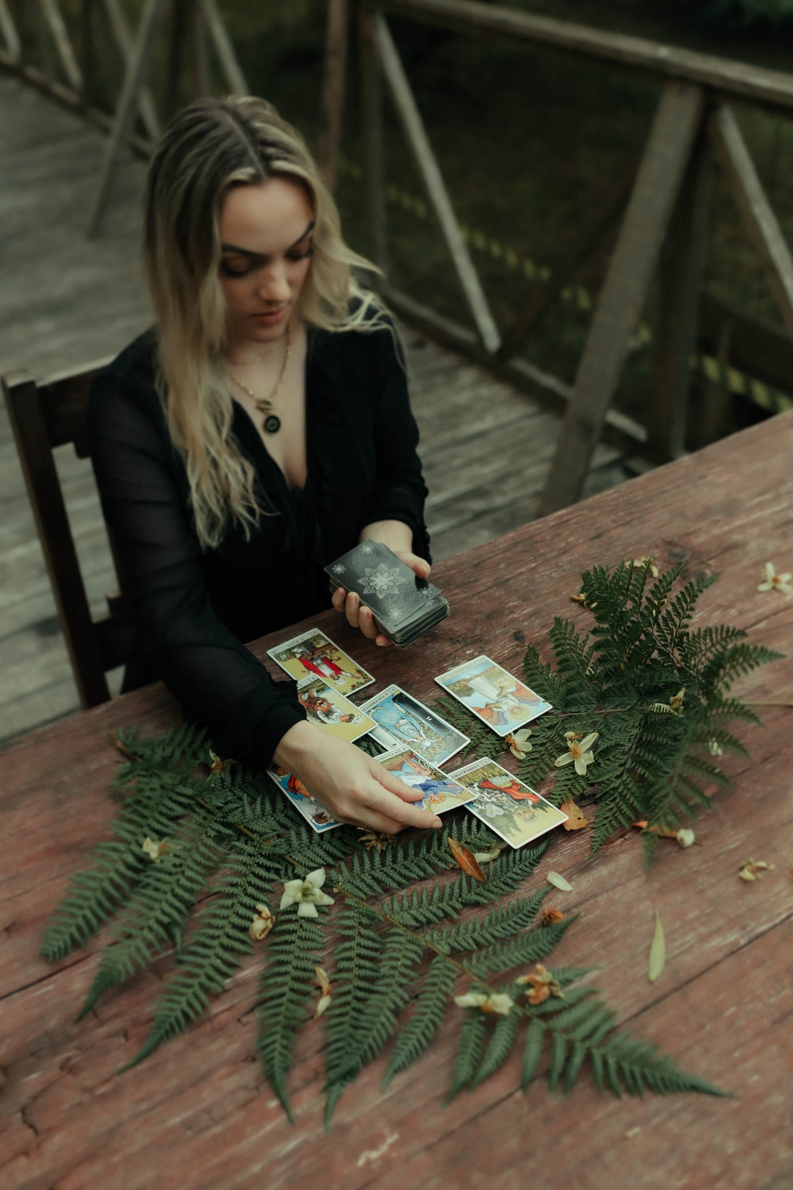 Ana com cartas e samambaias